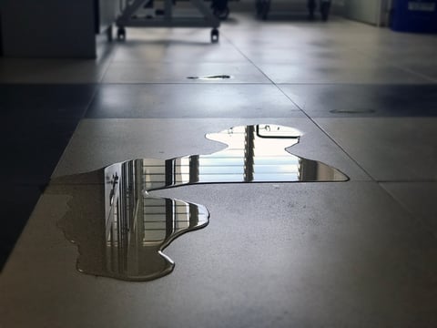 Water puddle on floor creating dangerous slip hazard