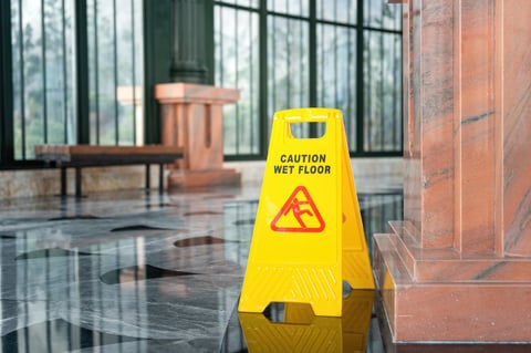 Wet marble floor with caution wet floor sign - slip hazard